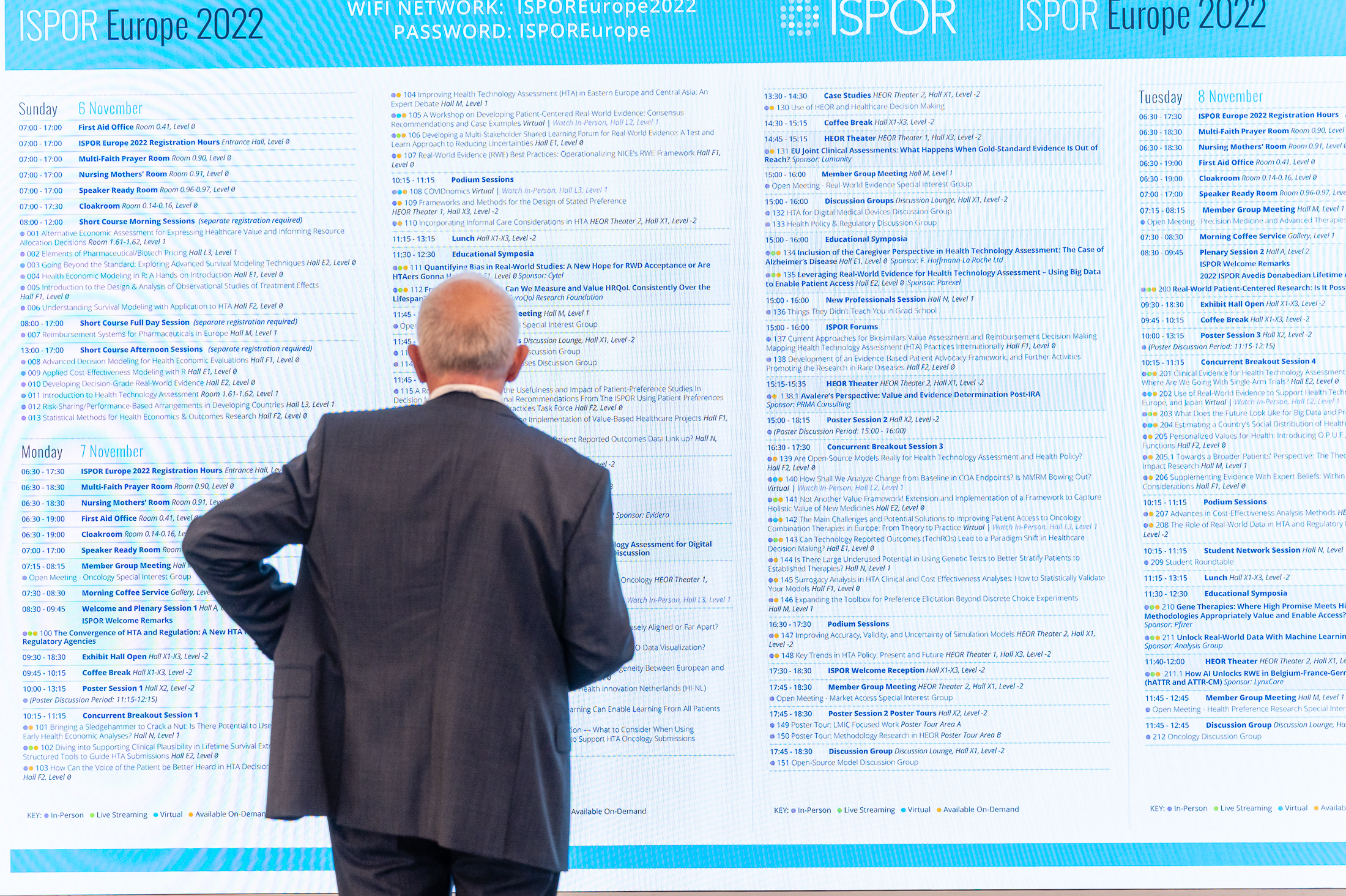 Delegate viewing a large screen monitor of the conference program